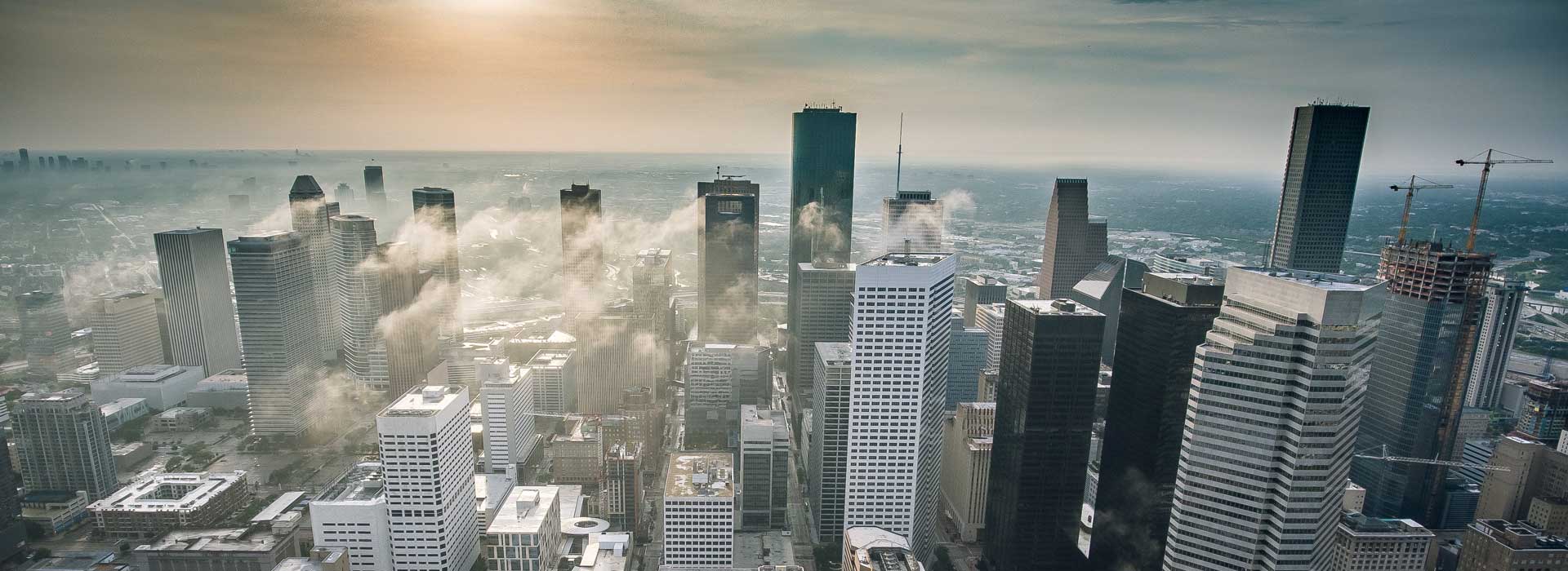 Aerial view of skyscrapers in Houston's downtown core as steam rises from some buildings