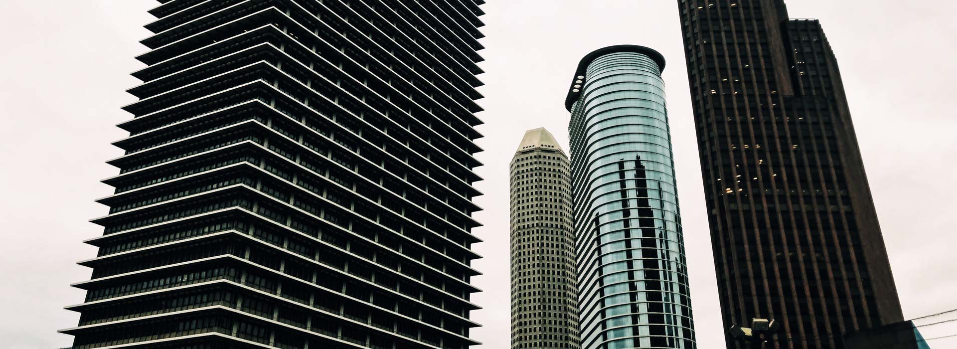 Four tall, commercial high-rise buildings stand next to each other